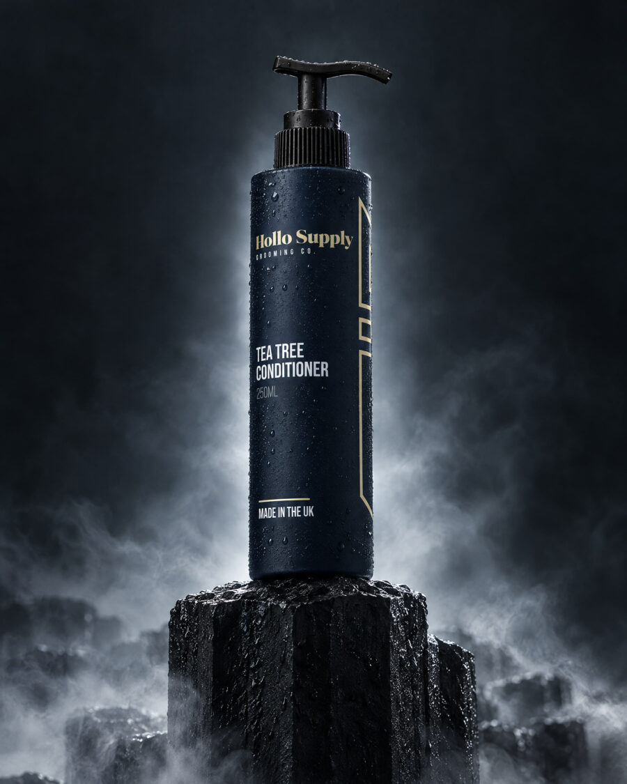 Tea Tree Conditioner by Hollo Supply Grooming Co., photographed on wet charcoal stone with water