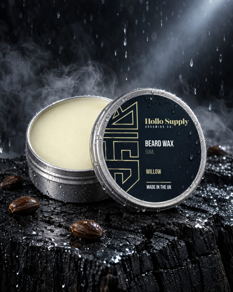 Beard Wax (Willow) by Hollo Supply Grooming Co., photographed on wet charcoal stone with water
